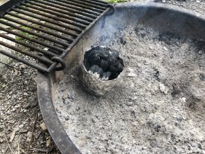charcoal in chimney in firepit with grate