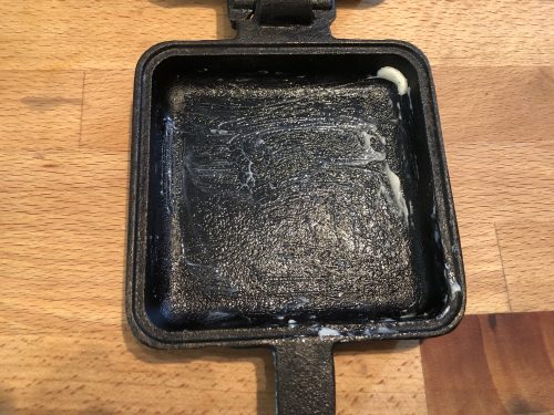 pie iron that has been buttered