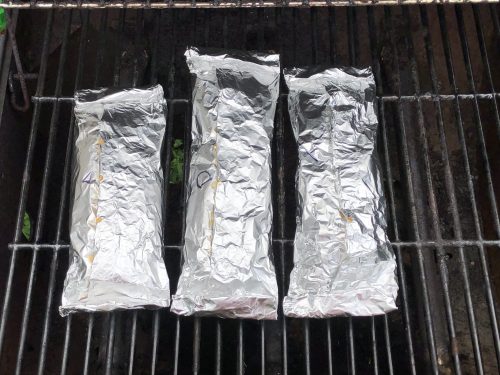 foil packets on the grill being cooked