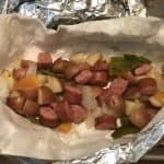 foil packet with sausage peppers onions and potatoes ready to eat