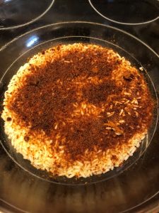 cajun seasoning added to rice in bowl