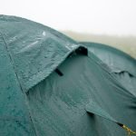 camping in the rain in a green tent