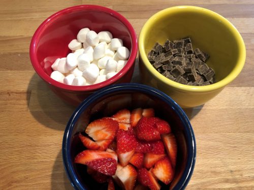 marshmallows, chocolate, strawberries in colorful bowls