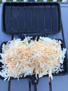 hash browns covered with cheese in double pie iron