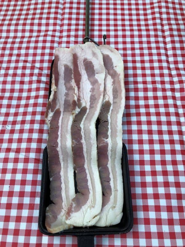 3 slices bacon laid out on square pie iron