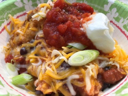 camping chili with cornbread plated with toppings