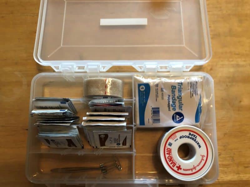 open tackle box with some items to aid in wound management such as moleskin, iodine, and tape