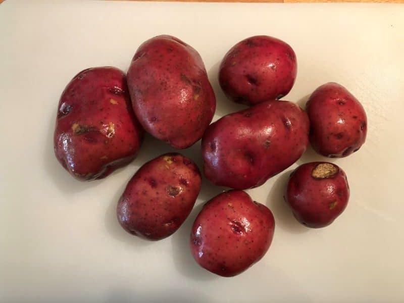 red potatoes washed and on a cutting board