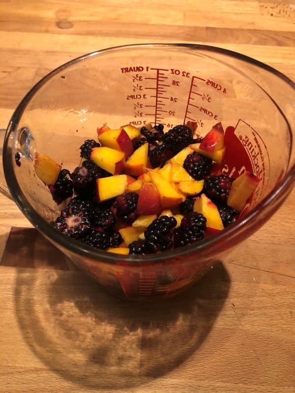 peaches and blackberries marinating in pyrex cup