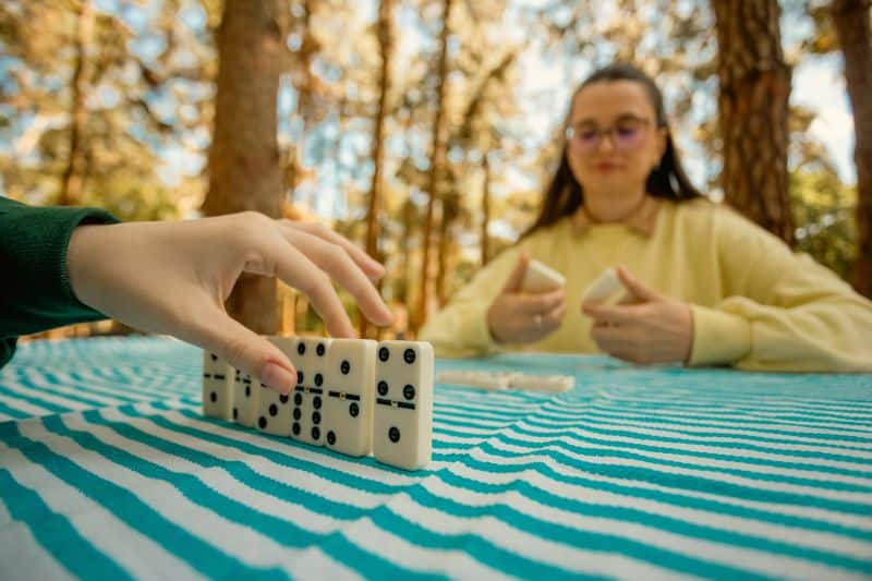 two girls playing dominoes outdoors