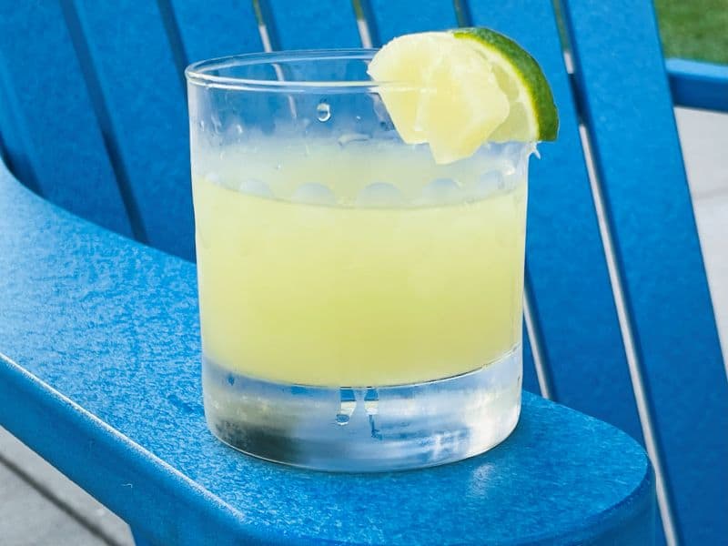 pineapple limeade in glass on blue chair